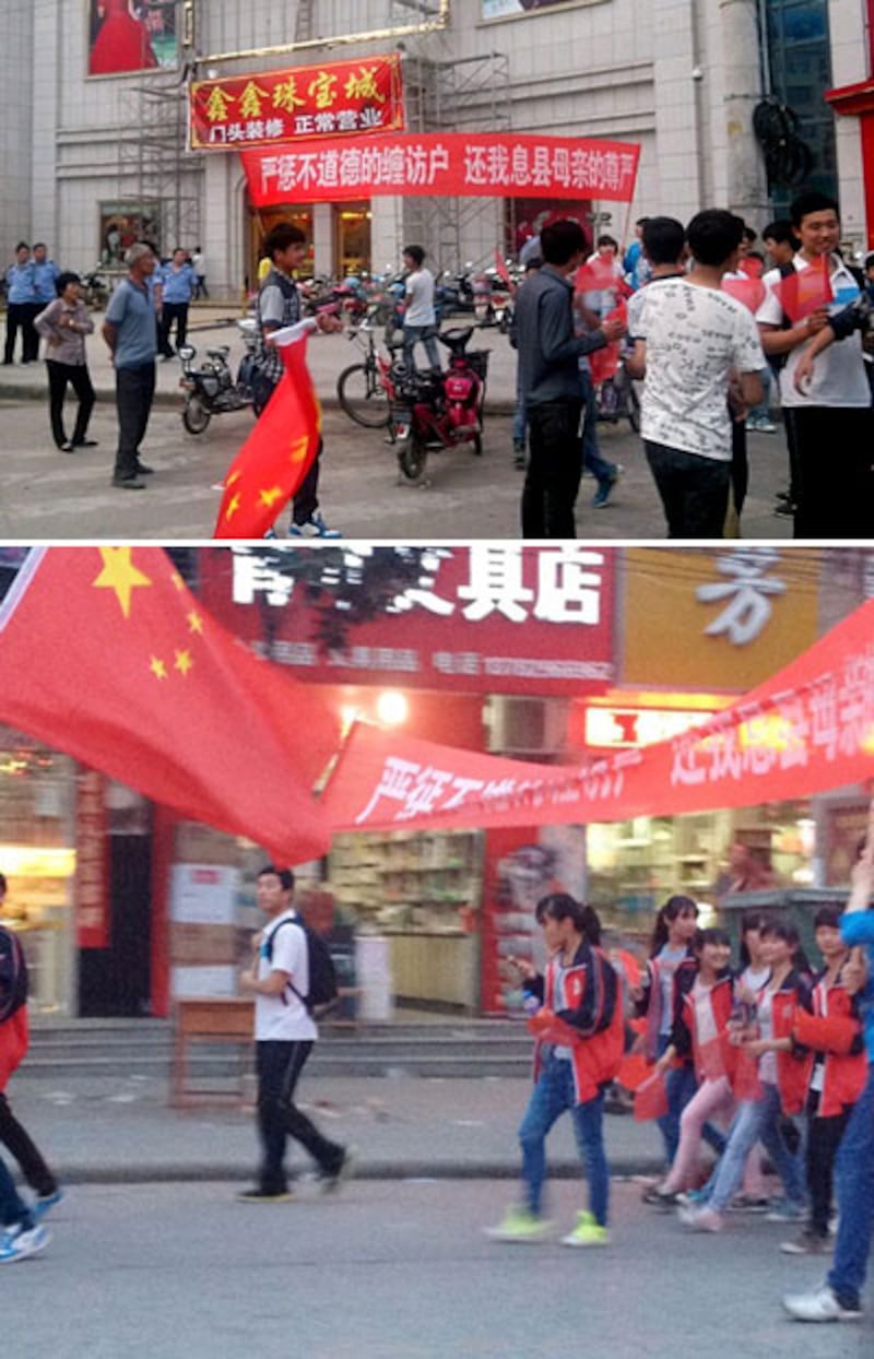 5月29日,河南息縣近百名中學生持國旗及横額遊行,抗議不道德纏訪戶。(中國天網)